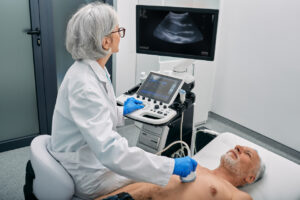 Cardiovascular sonographer performing echocardiogram on patient