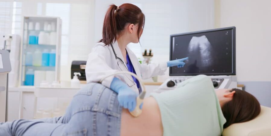 Ultrasound technician performing examination on patient