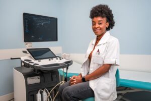 ultrasound technician sitting in front of machine