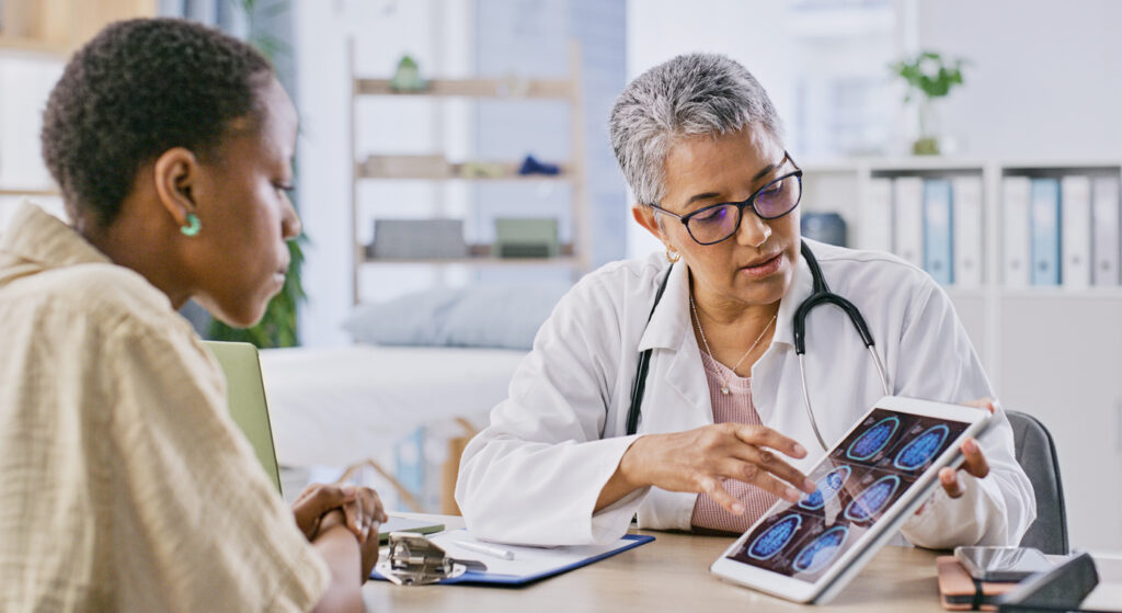 Doctor showing patient brain scans on a tablet