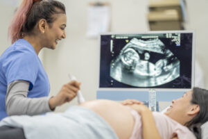 Ultrasound tech performing ultrasound on pregnant patient