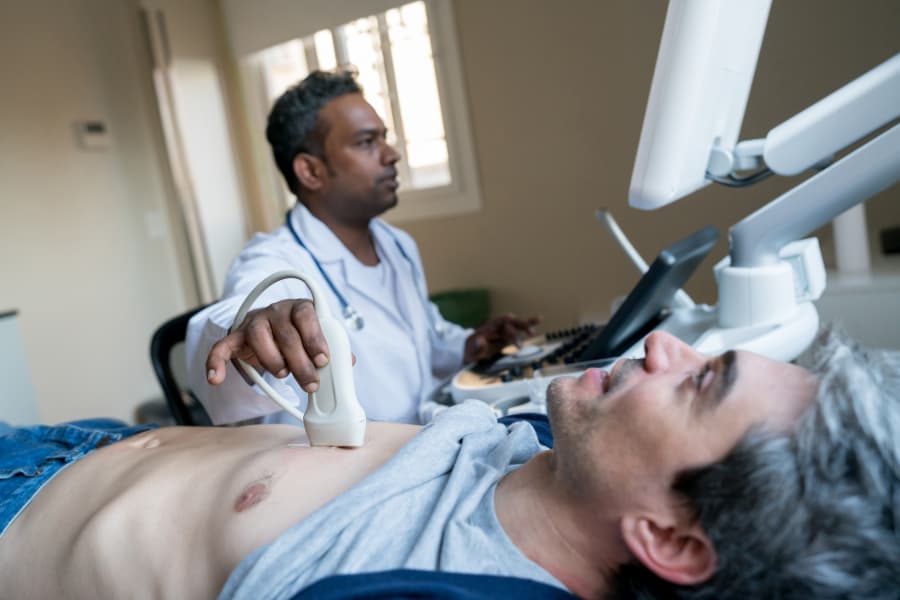 Doctor performing heart ultrasound on patient