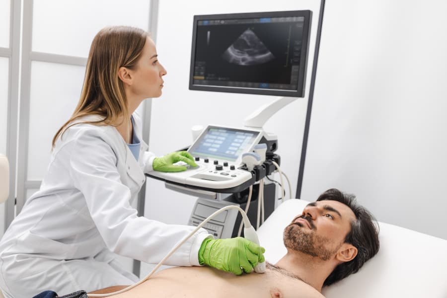 Ultrasound specialist performing heart ultrasound exam on patient