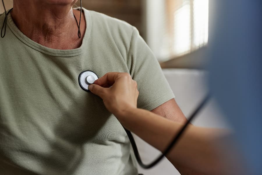 Close up of doctor listening to patient’s heartbeat with stethoscope