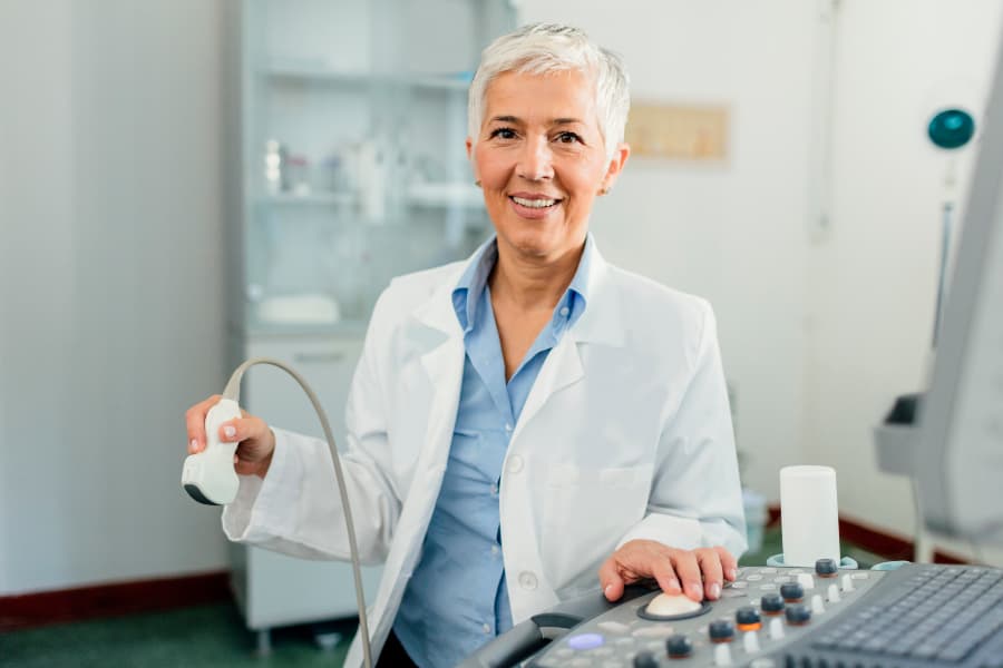 Doctor sitting in office holding ultrasound equipment