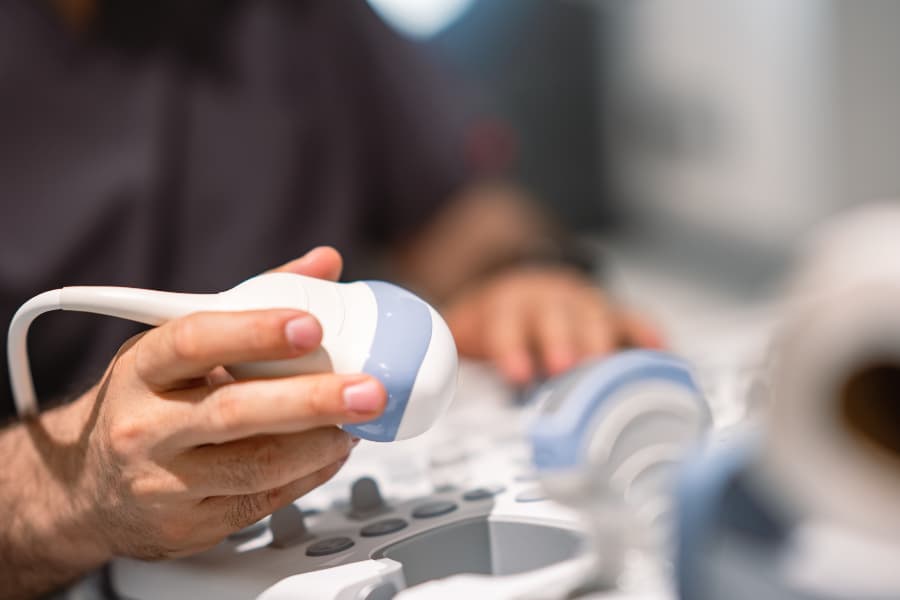Sonography technician holding ultrasound wand