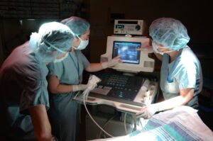 Doctors and nurses looking at ultrasound image in operating room
