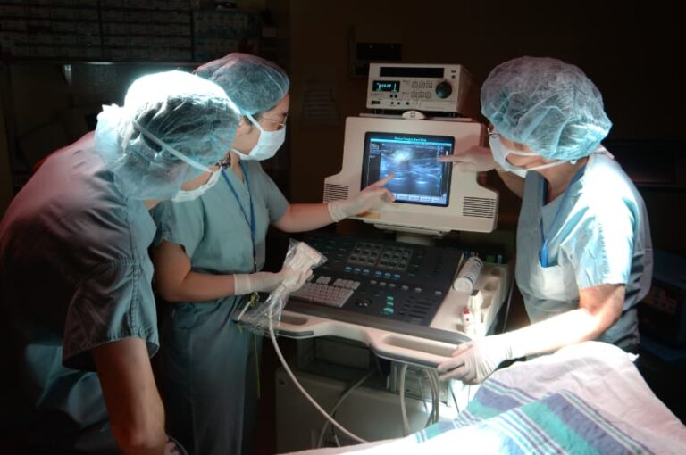 Doctors and nurses looking at ultrasound image in operating room