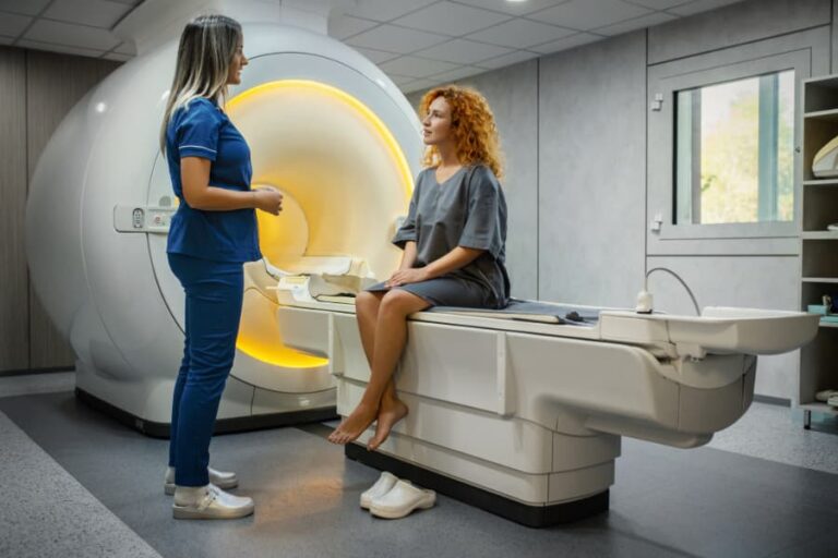 Medical technician easing patient nerves before MRI testing