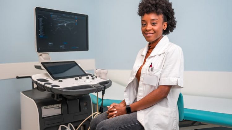 ultrasound-technician-sitting-in-front-of-machine ultrasound technician sitting in front of machine