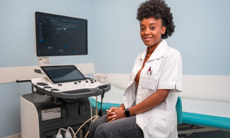 ultrasound-technician-sitting-in-front-of-machine ultrasound technician sitting in front of machine